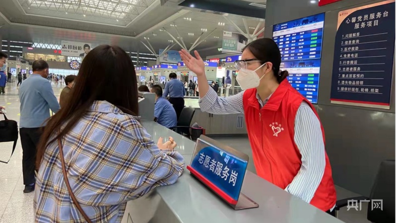郑州东站青年职工为旅客指引检票口位置(央广网发 通讯员 徐悦 供图)