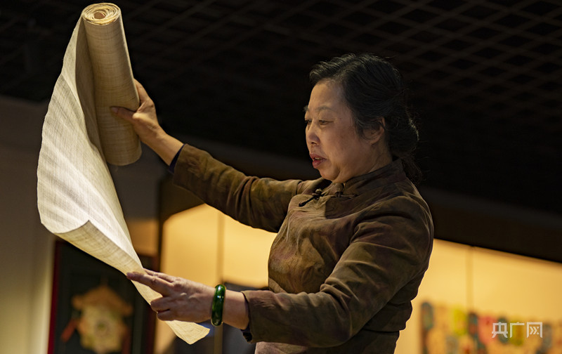 张小红在选择合适的夏布原料(央广网发 赵春亮 摄)进行作品的前期描绘