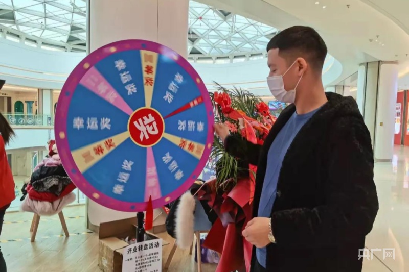 参与现场互动的人们正摇动抽奖转盘.央广网发