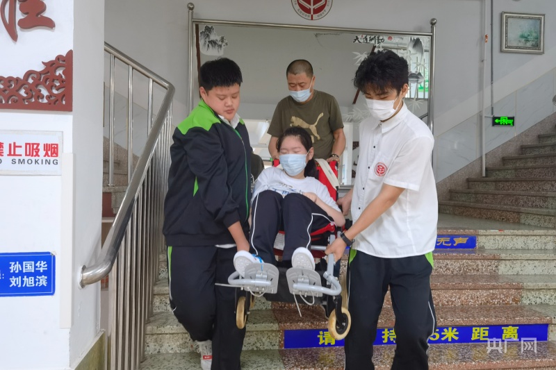 每天放学,两位男生把小艺璇抬下楼(央广网发  瓦房店市第二初级中学供