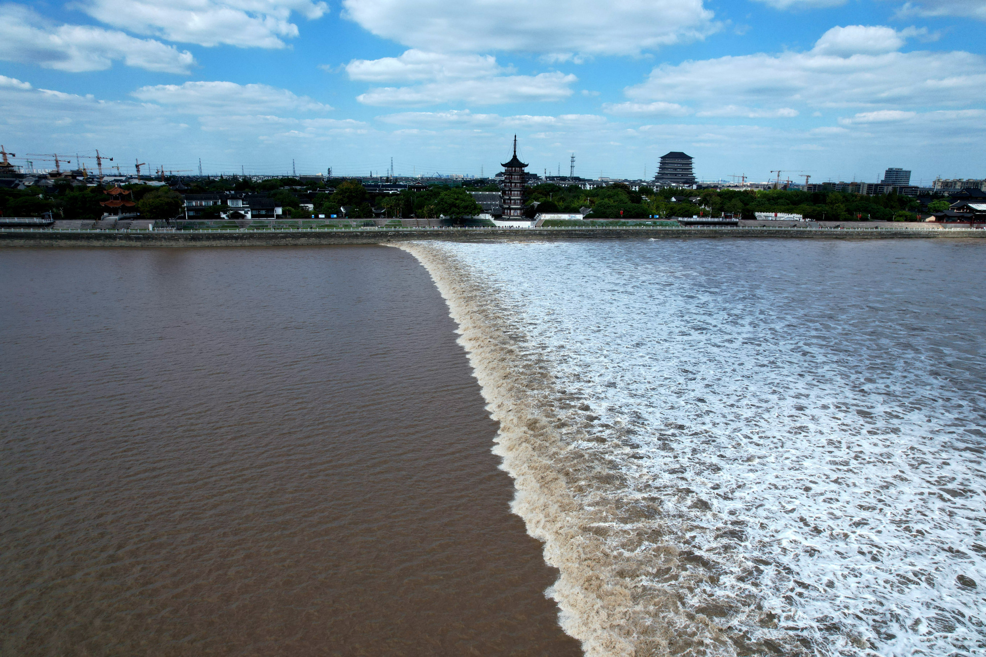 10月12日,钱塘江潮水似万马奔腾冲过北岸浙江省海宁市盐官观潮胜地