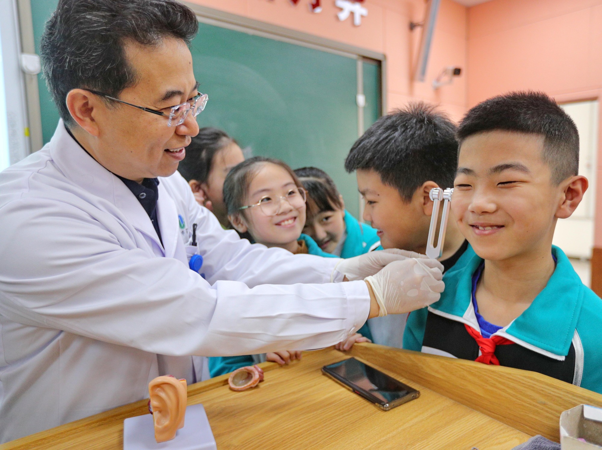 医生给学生讲解音叉的听力检查方法(央广网发  曹建雄  摄)