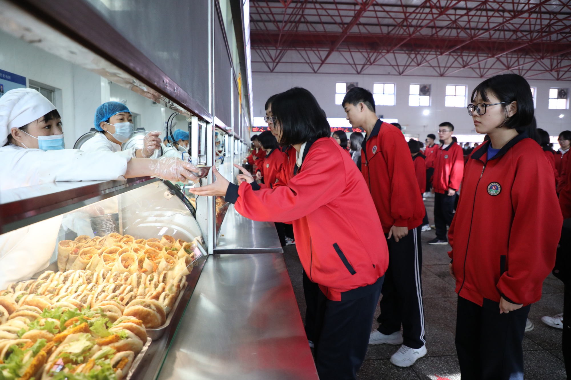 走进蠡县中学食堂,学生们有序排队打饭,食堂出口设有残羹回收桶,供