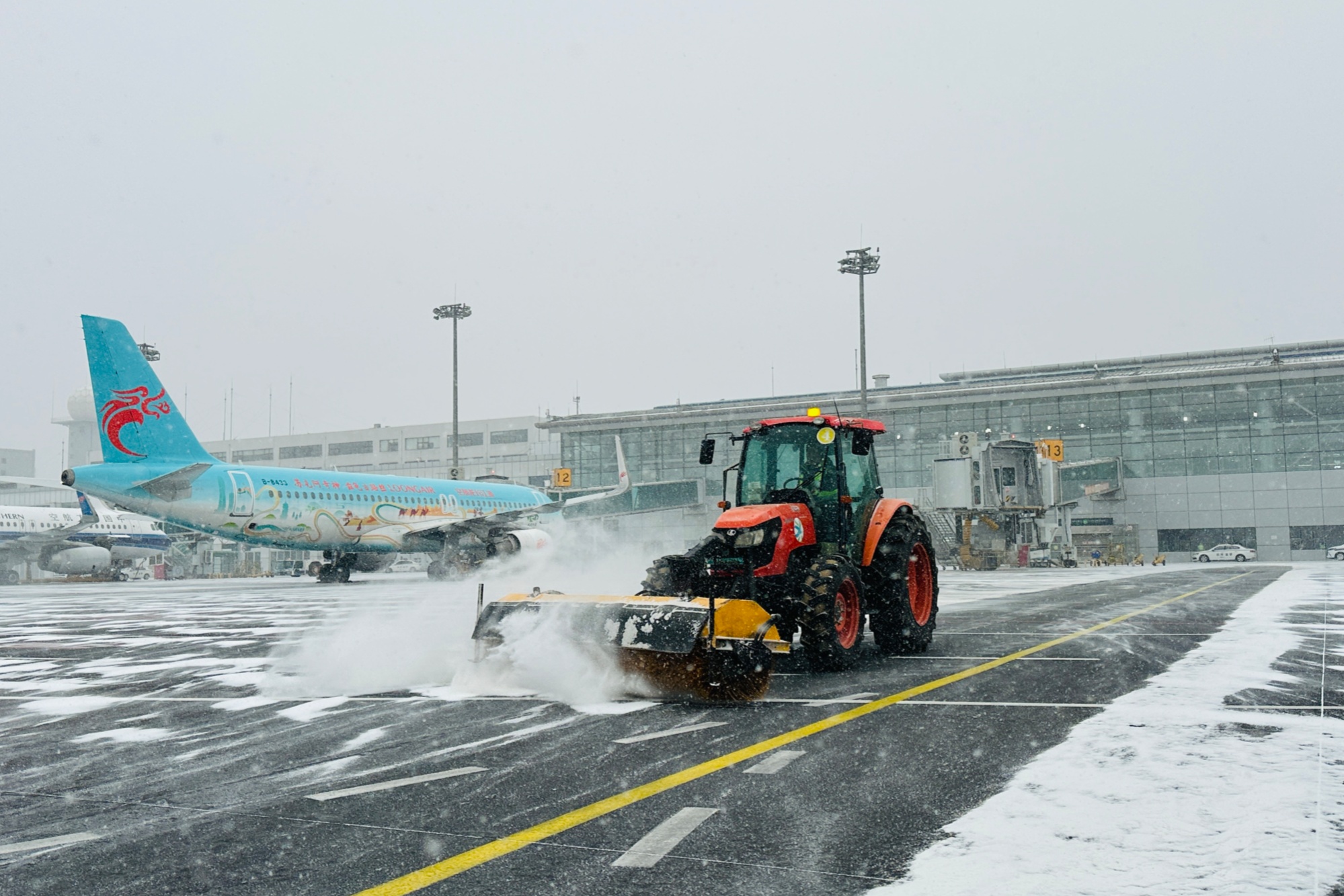 提前预案即降即扫  雪天大连机场航班未受影响
