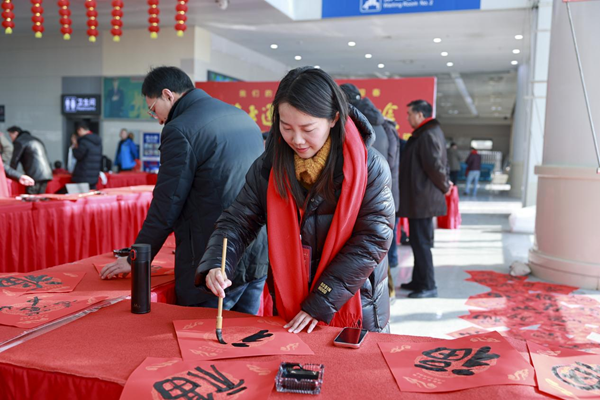 泰州市书法家协会主席孙志勇(左)给旅客送"福"(央广网发  毛晓华  摄)