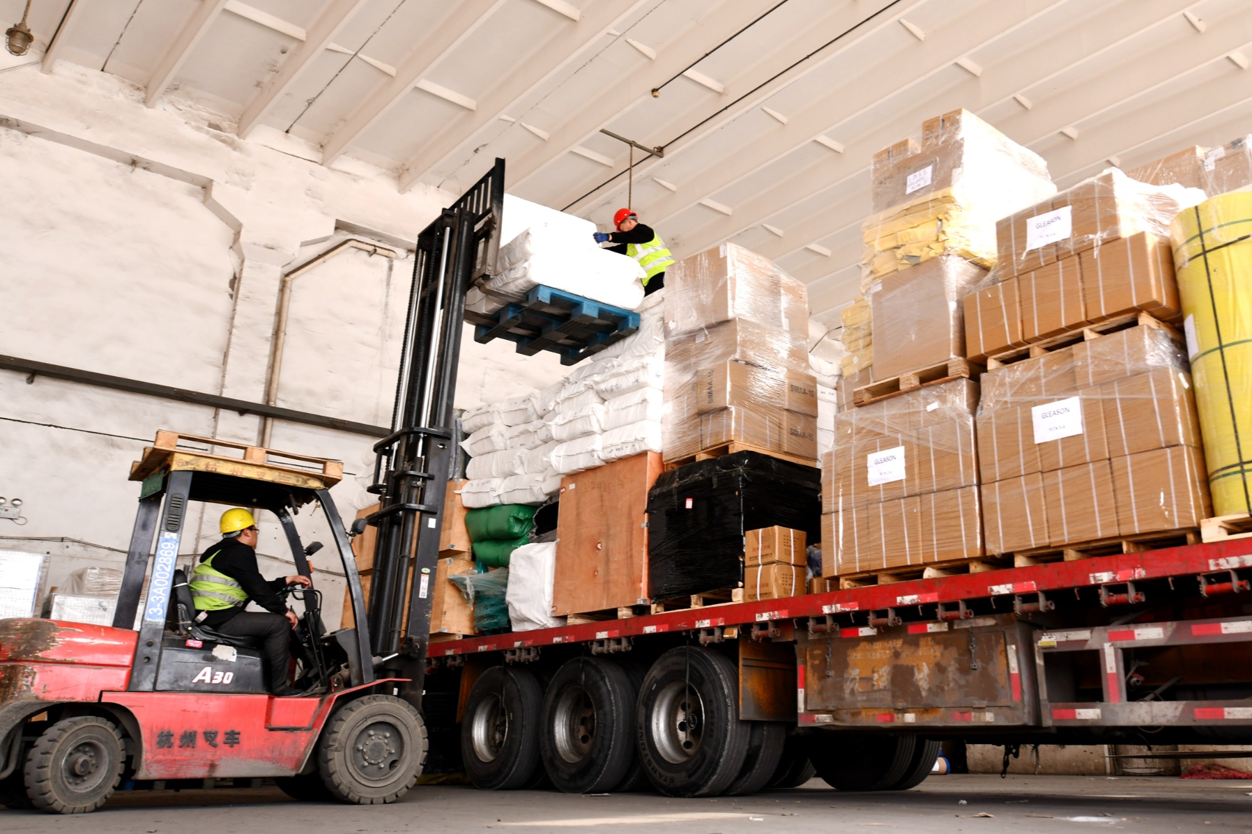 货车往来频繁,叉车不停地卸货,装货,装载完毕的大货车整装待发,整个