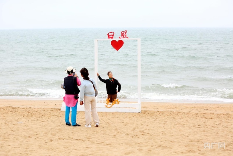 游客在海边网红打卡地拍照留念(央广网记者  唐磊  摄)骑行爱好者在