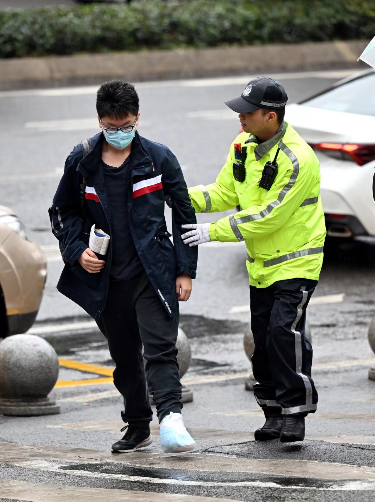 骁骑队员张鹏搀扶受伤考生前往考场(九龙坡区公安分局供图)民警在重庆