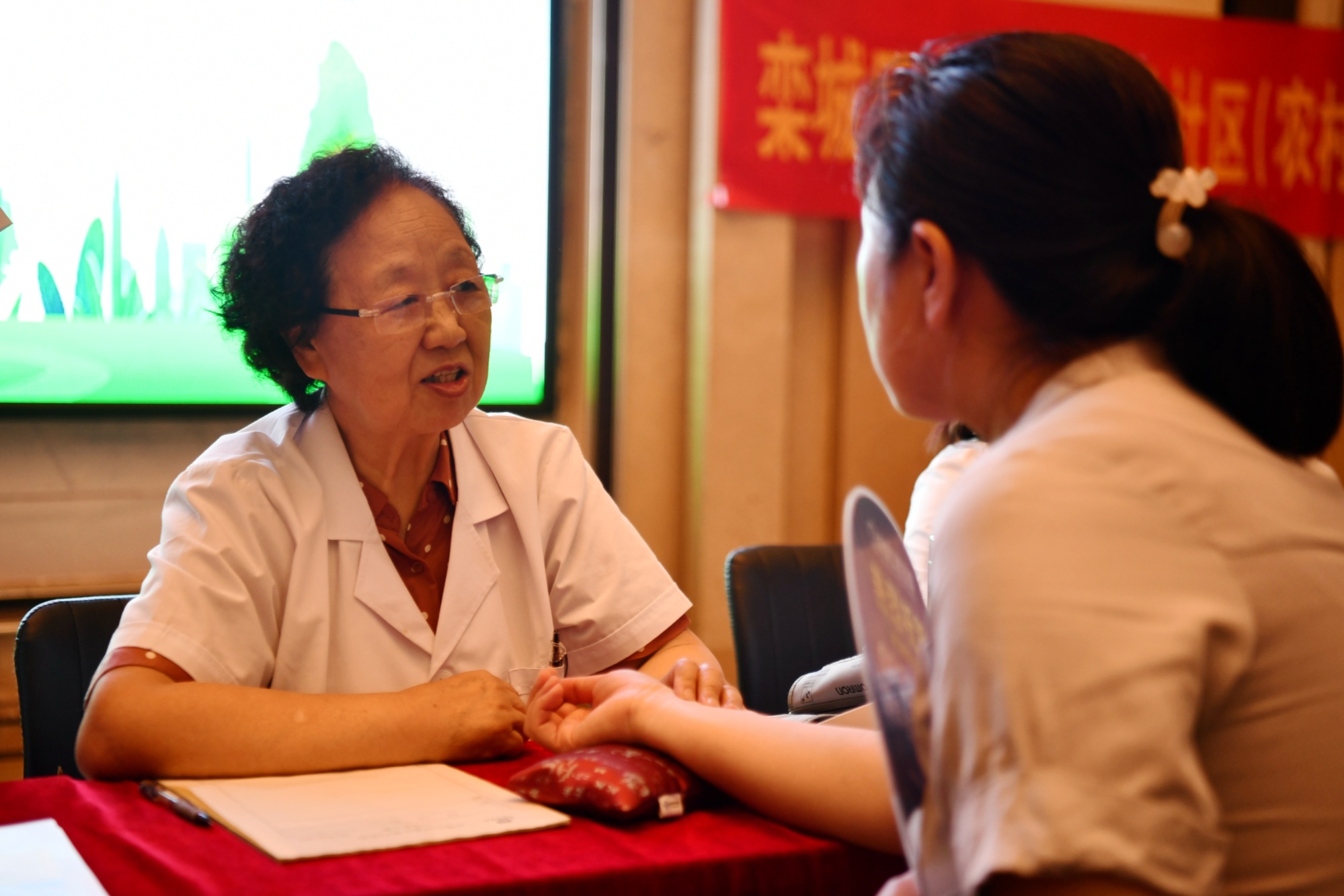 医务志愿者为居民把脉义诊(李明发  摄)6月13日,河北省石家庄市栾城区