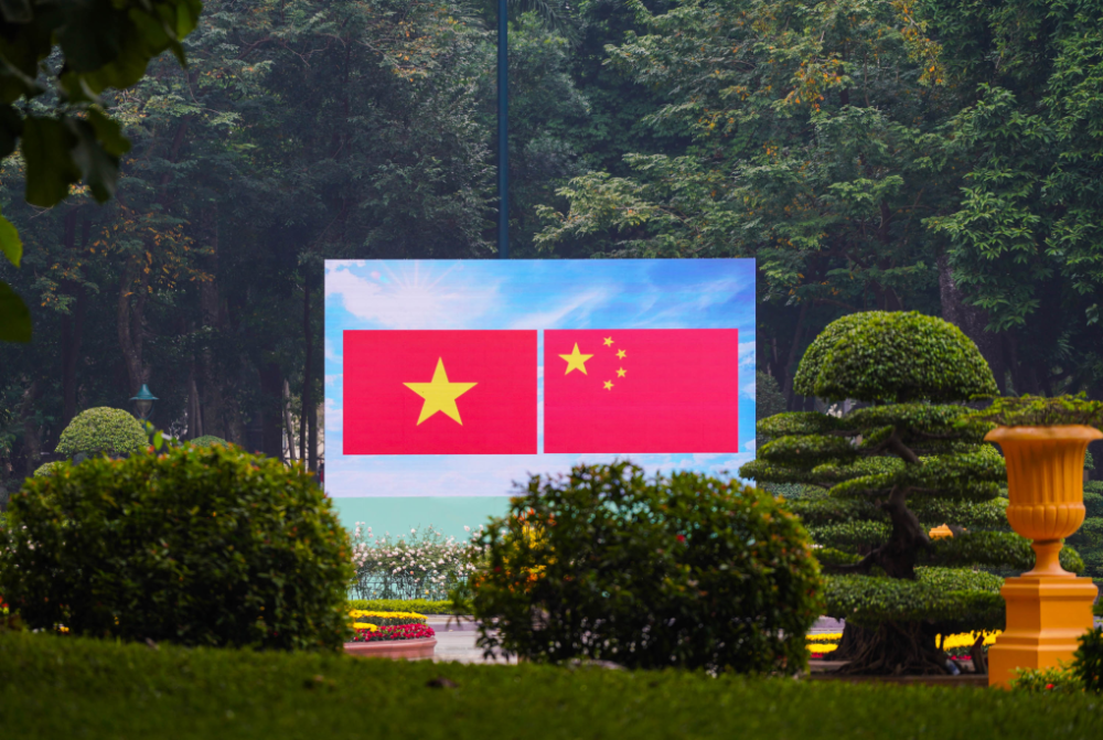 12月9日,在越南主席府外的广场上,记者看到大屏幕上并列展示中越两国