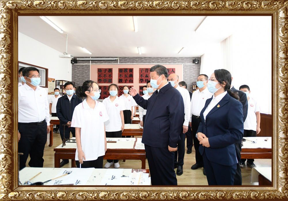 14日上午,习近平在绥德实验中学考察时,同正在练习书法的学生亲切交流
