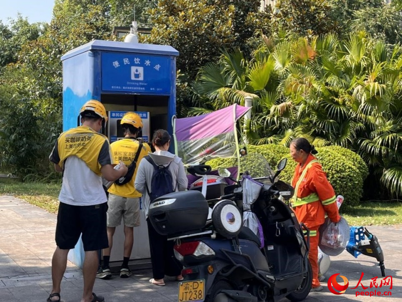 9月5日，正在“0011”号便民饮水点排队接水的市民。周小平摄