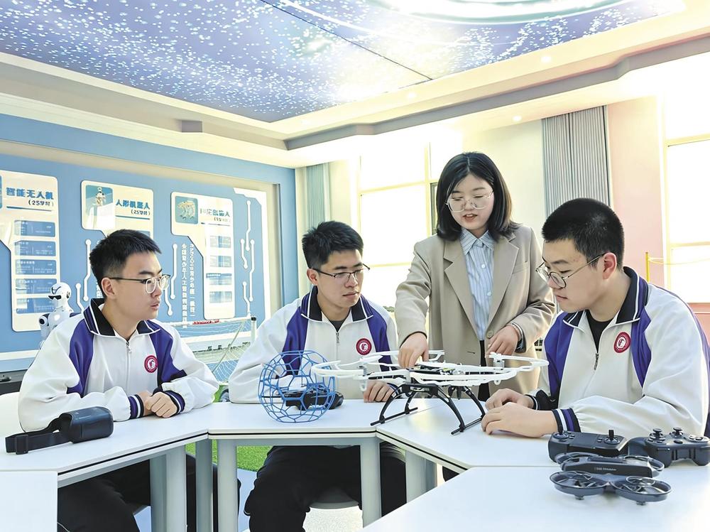赵天(左二)正在和老师同学探讨无人机相关问题。本报记者 王宥力 摄